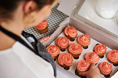 Buy stock photo Woman, baker and cupcake in kitchen working, startup and business with employee for treat or dessert with packaging. Creative, frosting and order preparation for customer, back view and apron