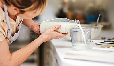 Buy stock photo Cropped shot of a young woman measuring milk while baking at home
