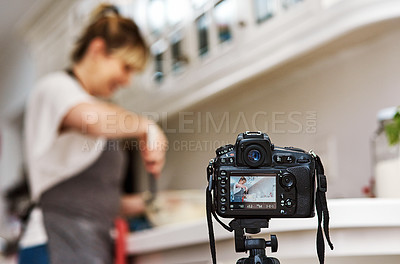 Buy stock photo Cropped shot of a woman being filmed while baking in her kitchen