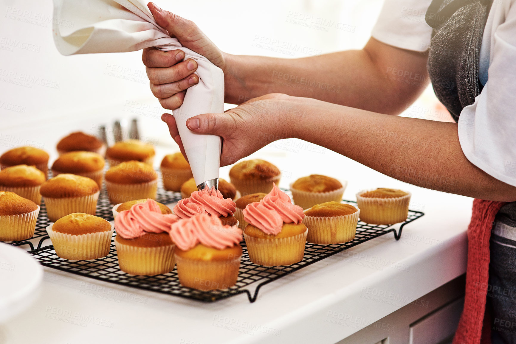 Buy stock photo Person, baker and cupcake in kitchen and frosting, start up and business with employee for treat or dessert. Creative, icing and order preparation for customer, bakery and apron and party bag