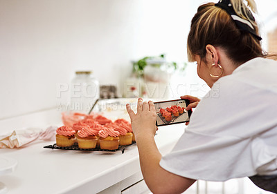 Buy stock photo Cropped shot of a woman taking pictures of her homemade cupcakes