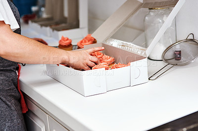 Buy stock photo Cropped shot of an unrecognizable baker packing cupcakes in a box