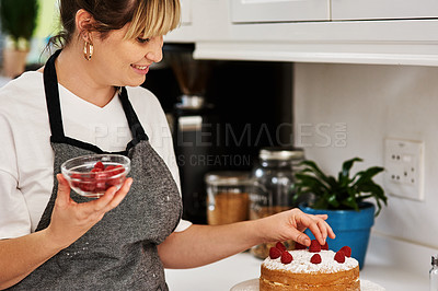 Buy stock photo Cropped shot of a woman decorating a cake in her kitchen