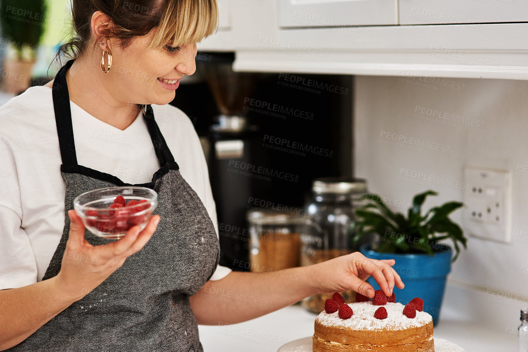 Buy stock photo Cake, decoration and woman with raspberry in kitchen for confectionery, bakery and creativity in food. Sweet, snack and dessert with fruit on table for pastry shop, preparation and small business