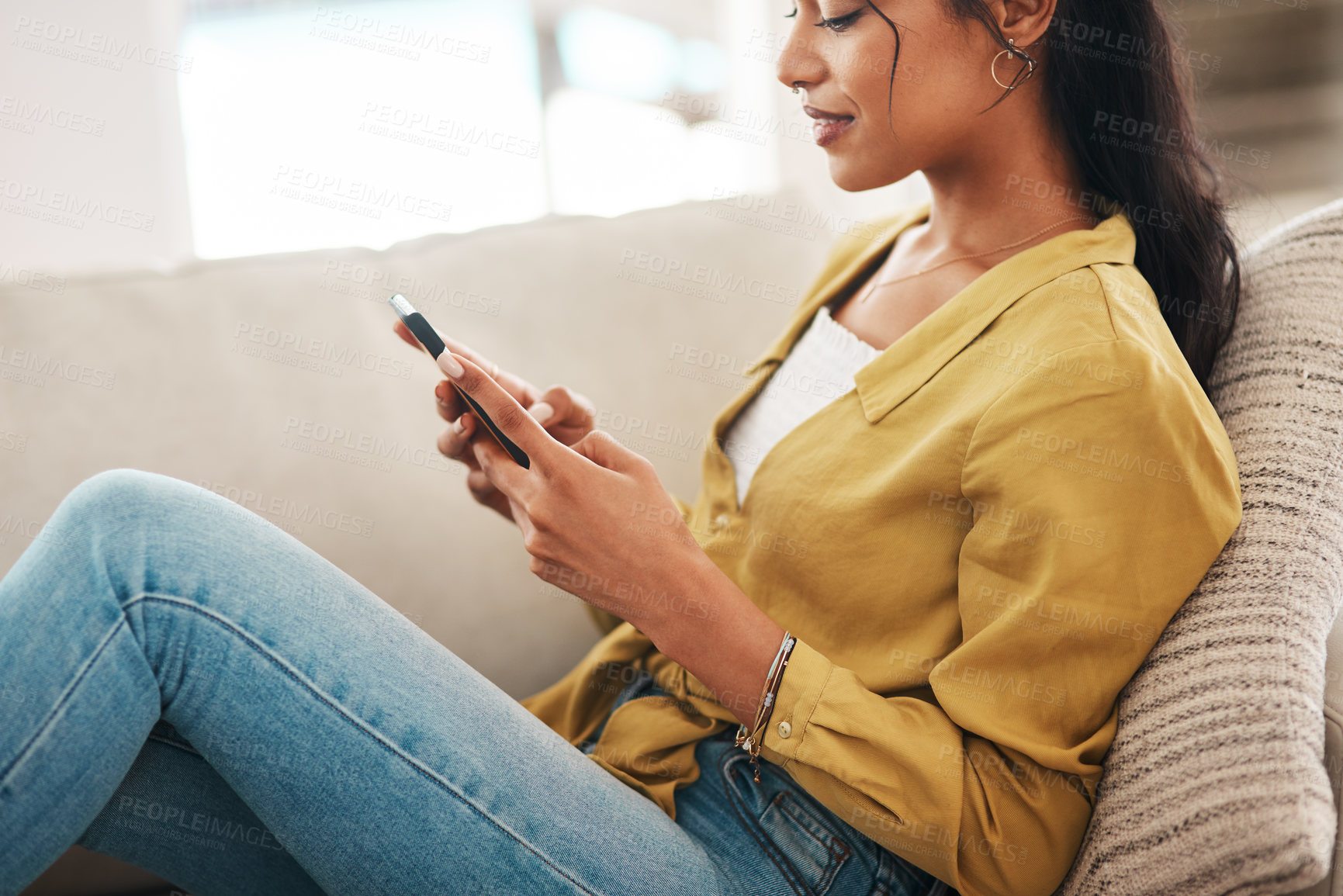 Buy stock photo Hands, phone and wellness with woman on sofa in living room of home for break or weekend time off. App, social media and relax with happy African person in apartment for communication or ecommerce