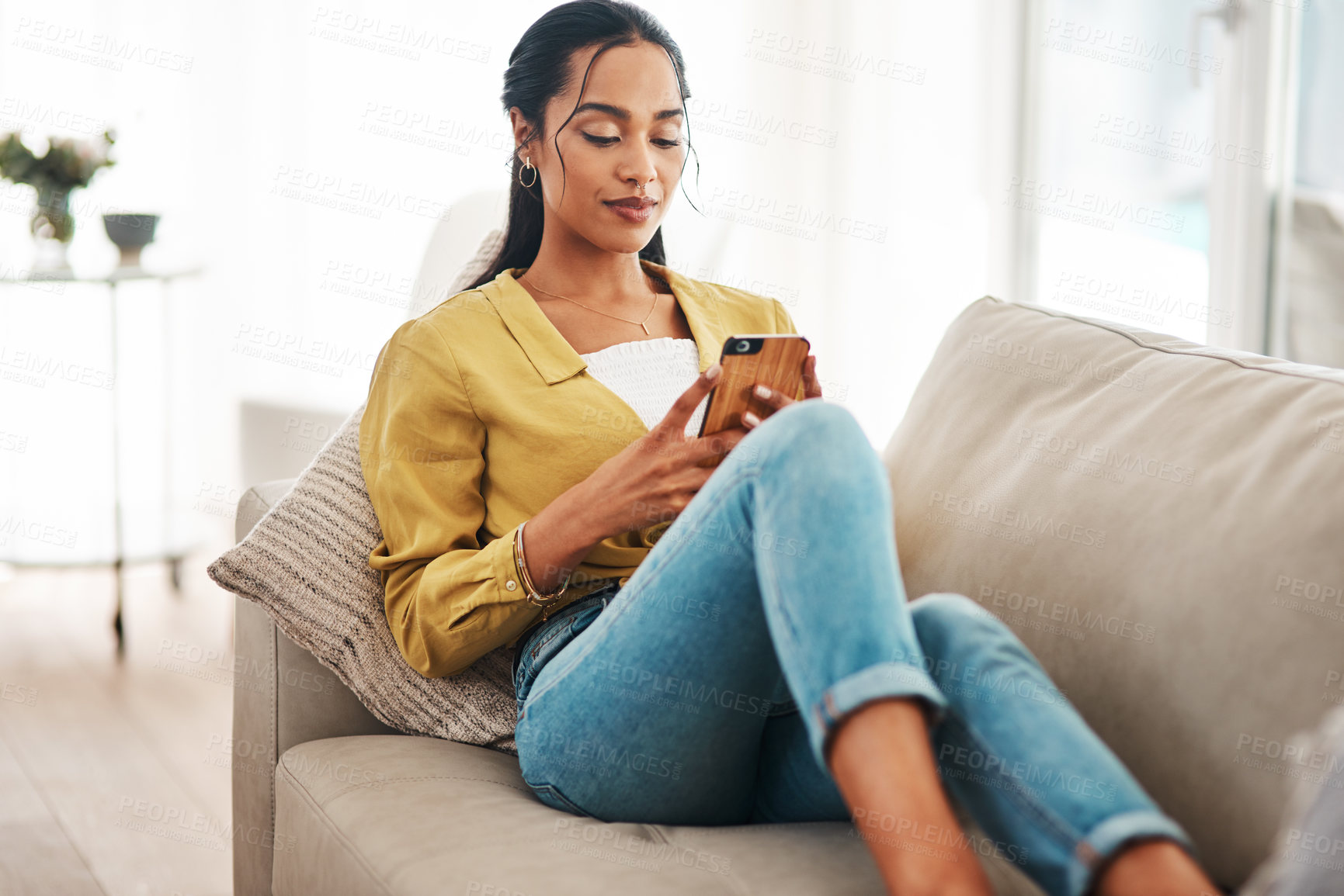 Buy stock photo Phone, relax and social media with woman on sofa in living room of home for break or weekend time off. App, text message and wellness with African person in apartment for communication or ecommerce