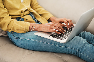 Buy stock photo Cropped shot of an unrecognizable businesswoman sitting on her couch and blogging from her laptop while at home