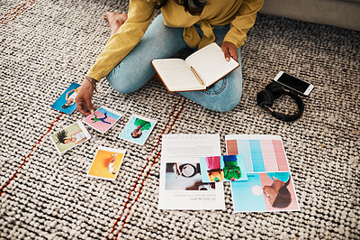 Buy stock photo Cropped shot of an unrecognizable businesswoman sitting on her living room floor and going through polaroids for her blog