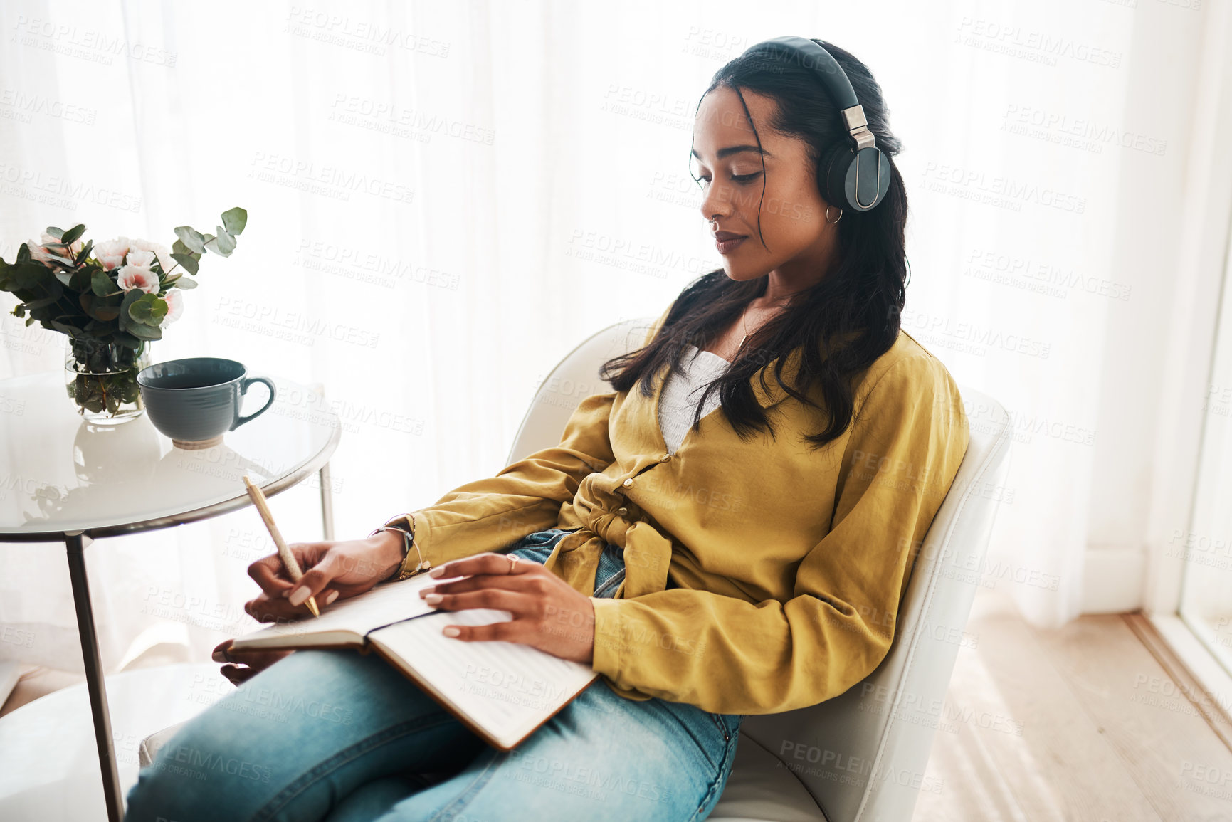 Buy stock photo Woman, apartment and wiring on diary with headphones for music, audio or podcast on chair. Female person, home and journaling for therapy or mindfulness in living room for motivation or inspiration