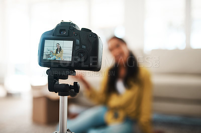 Buy stock photo Cropped shot of an attractive young businesswoman sitting in her living room and using her camera to record her vlog