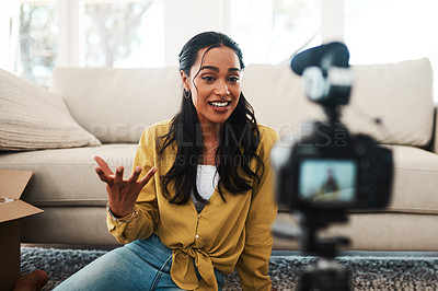 Buy stock photo Cropped shot of an attractive young businesswoman sitting in her living room and using her camera to record her vlog