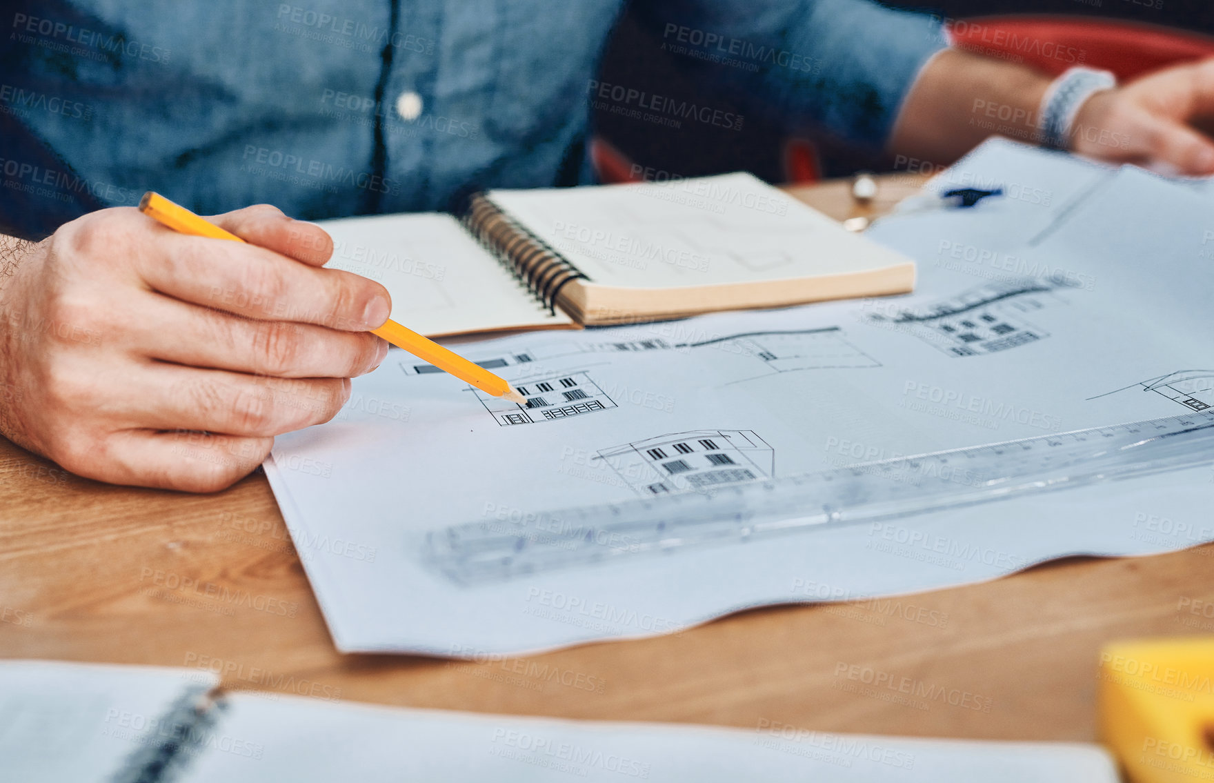 Buy stock photo Cropped shot of an unrecognizable male architect working with blueprints in a modern office