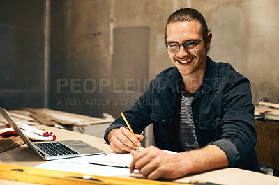 Buy stock photo Portrait of a focused young male carpenter working on a project inside of a workshop at night