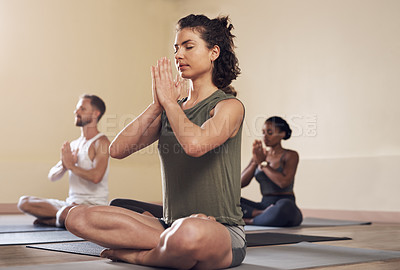 Buy stock photo Full length shot of a group of young people meditating and practicing yoga together inside a yoga studio