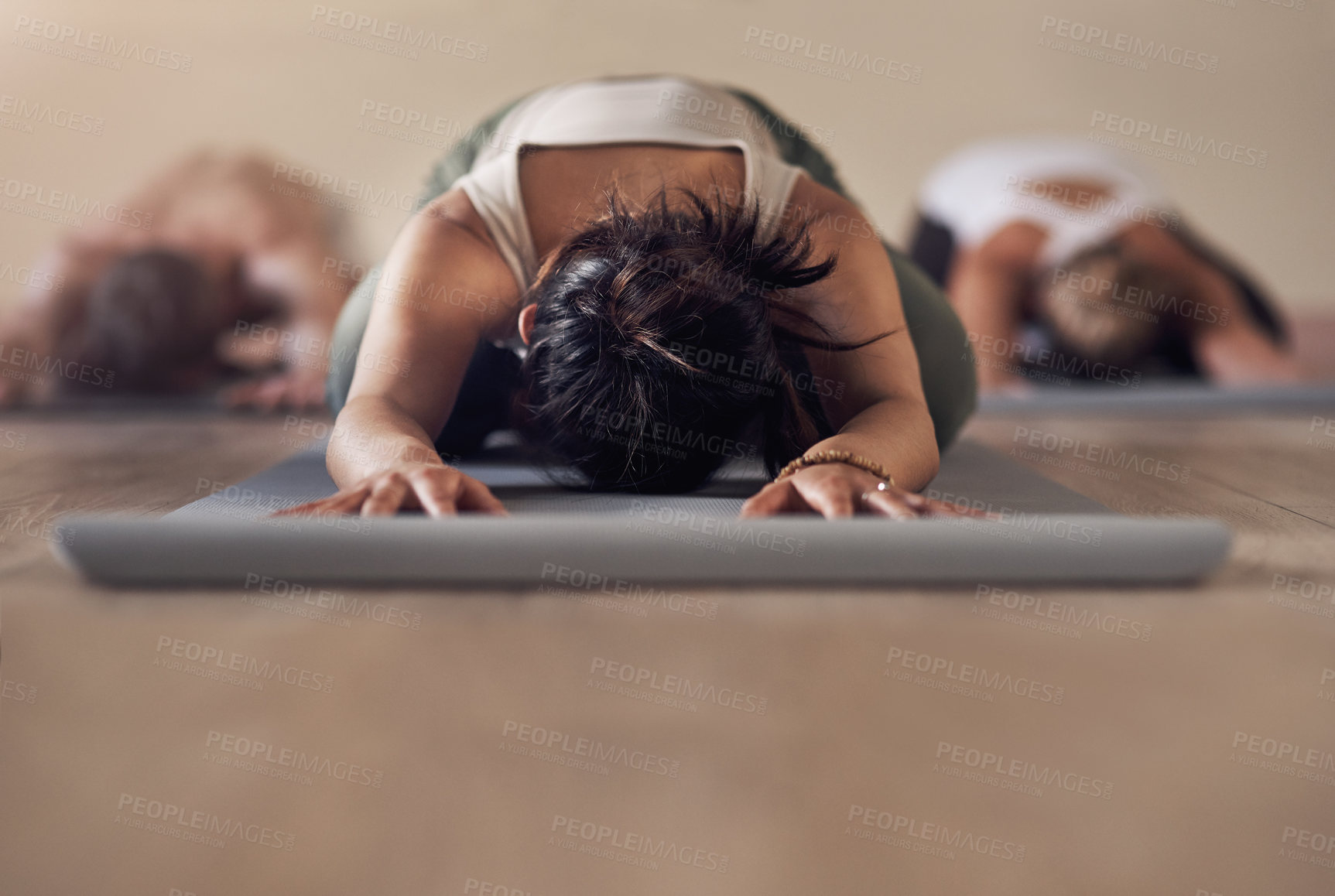 Buy stock photo Shot of a group of unrecognizable people meditating and working out together in a yoga class
