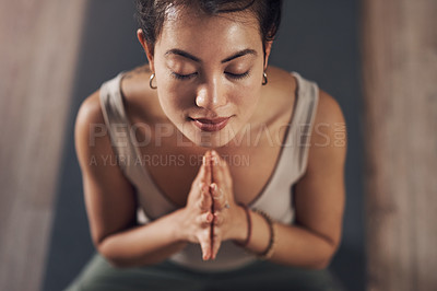 Buy stock photo Shot of an attractive young woman meditating and practicing yoga indoors
