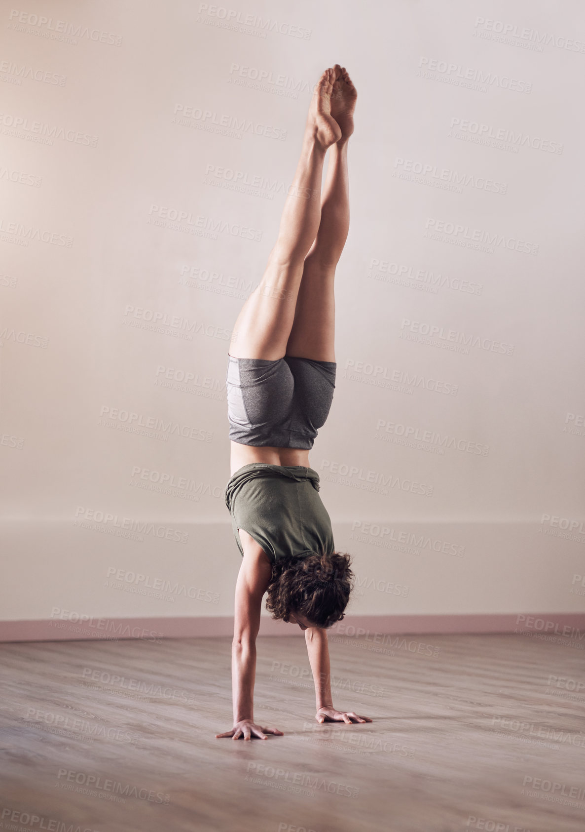 Buy stock photo Full length shot of an athletic young woman doing a hand stand in studio