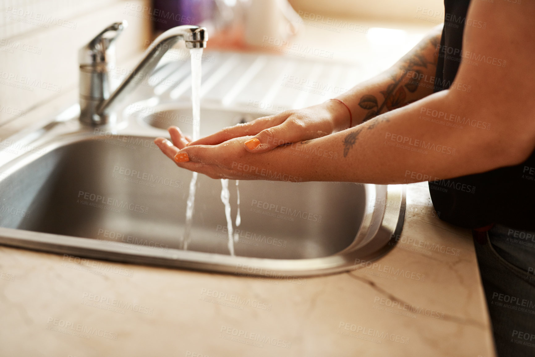 Buy stock photo Cropped shot of a woman washing her hands at the kitchen sink
