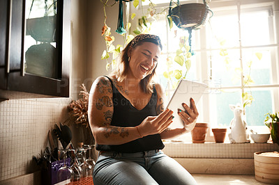 Buy stock photo Shot of a young woman using a digital tablet in the kitchen at home