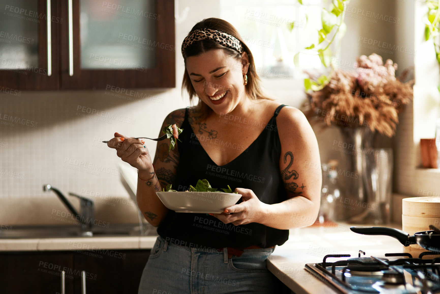 Buy stock photo Woman, diet and person eating salad in her home kitchen and is happy for a meal with nutrition or healthy lunch. Smile, food and young female vegan in her apartment or house and eat vegetables