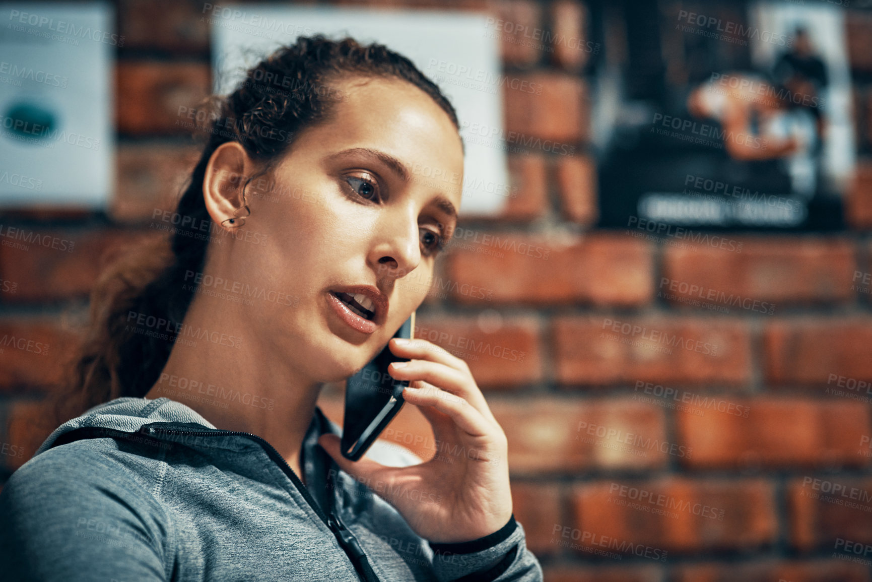 Buy stock photo Face, fitness and phone call with personal trainer woman in  gym for communication or networking. Brick wall, exercise and workout coach talking on mobile for membership offer or recruitment