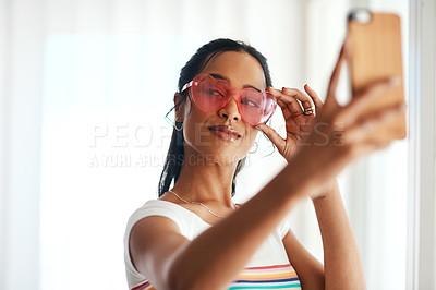 Buy stock photo Cropped shot of an attractive young blogger standing and wearing heart shaped glasses for a selfie with her cellphone