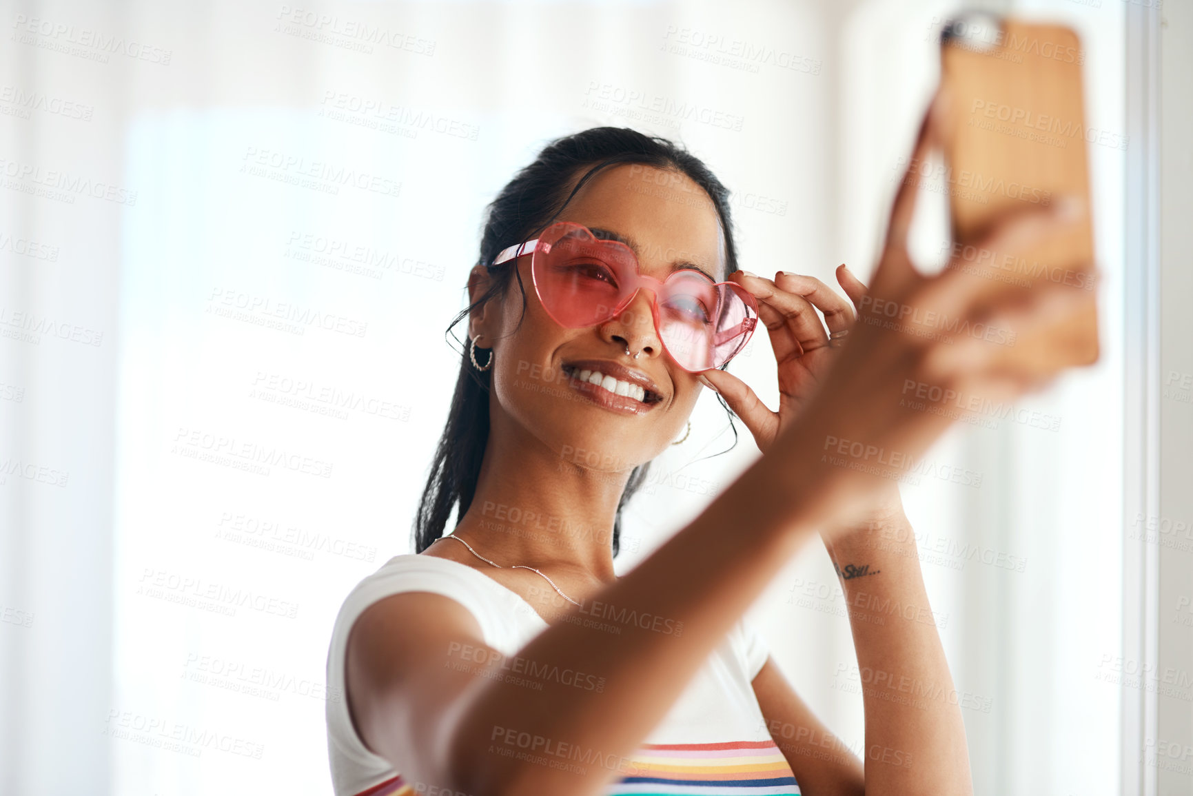 Buy stock photo Woman, smartphone and selfie for profile picture, vlog or social media post at home. Happy,  influencer or creative vlogger with casual fashion, heart glasses and photo in living room with smile