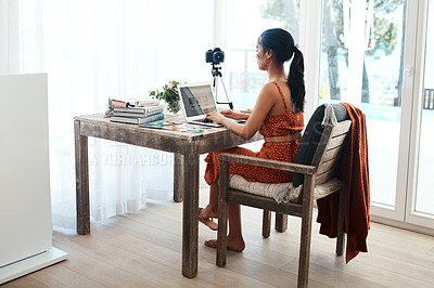 Buy stock photo Full length shot of an attractive young businesswoman sitting in her home office and using her laptop