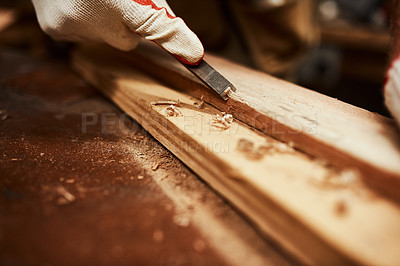 Buy stock photo Closeup of an unrecognizable carpenter filing down a piece of wood inside of a workshop at night
