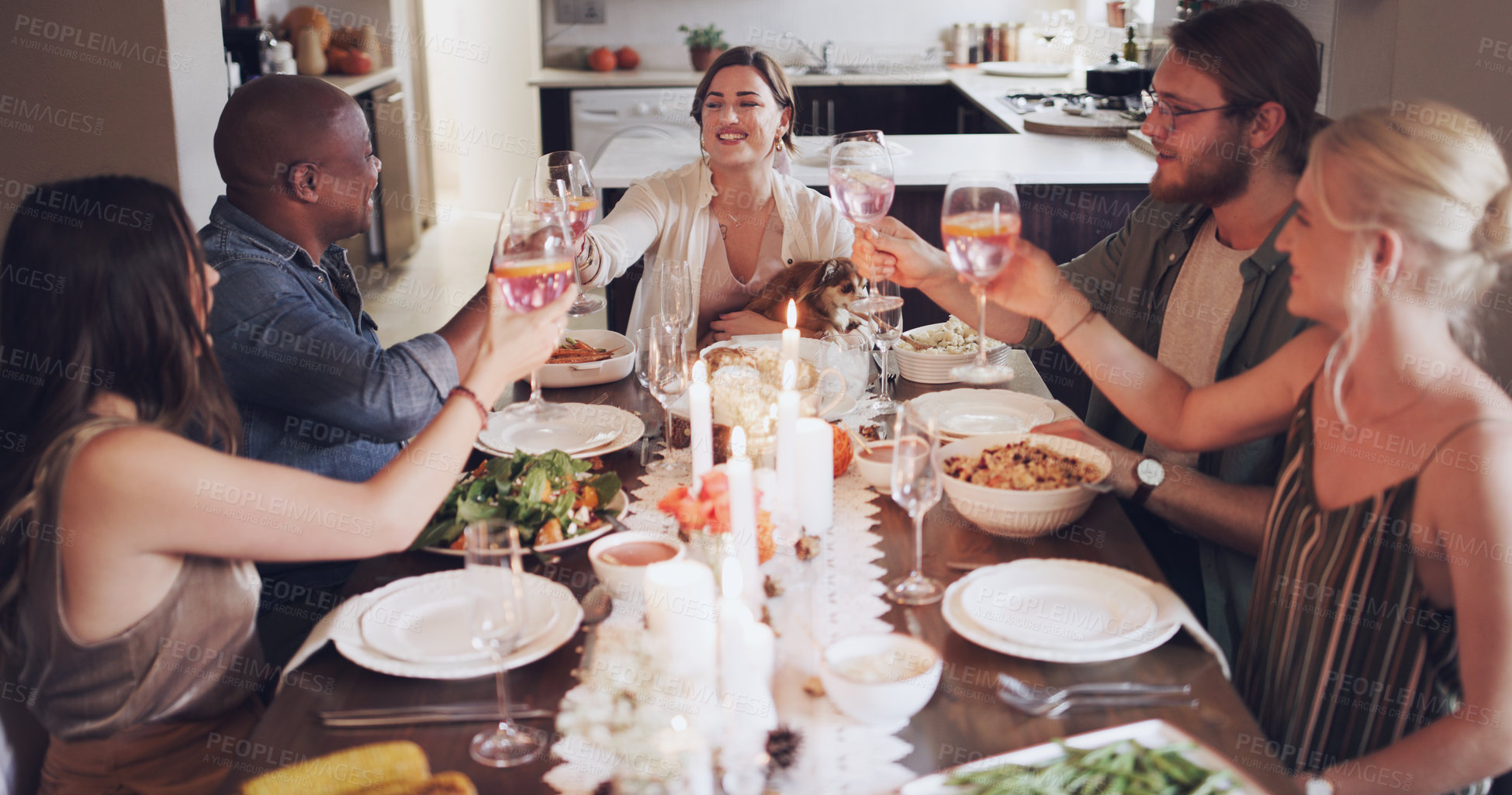 Buy stock photo Shot of a group of young friends toasting with wine at a Christmas dinner party