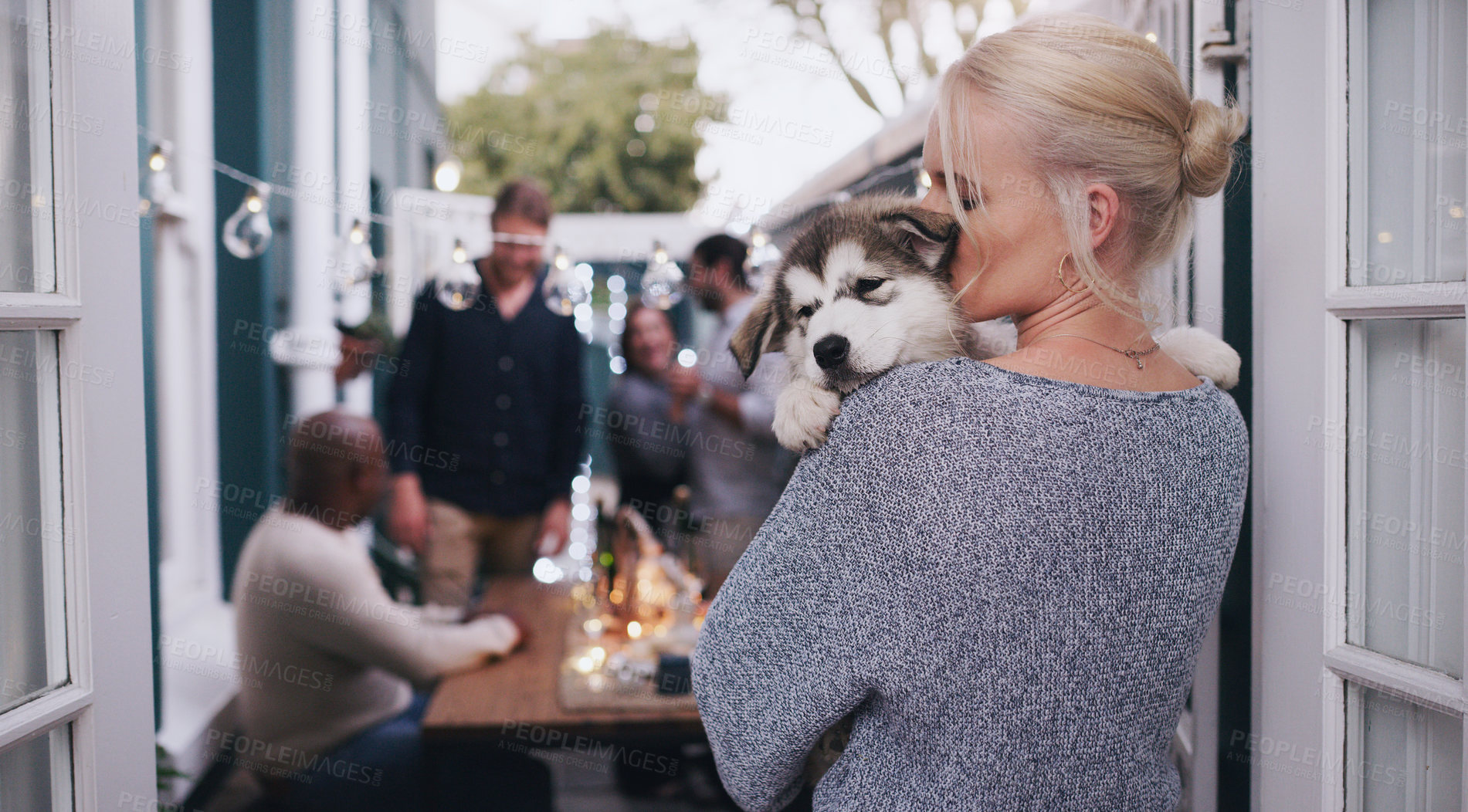 Buy stock photo Love, dog hug and woman at a house party, happy celebration and friends in a backyard during a holiday. Social content, lunch and girl with a husky puppy at a home dinner in a garden with people