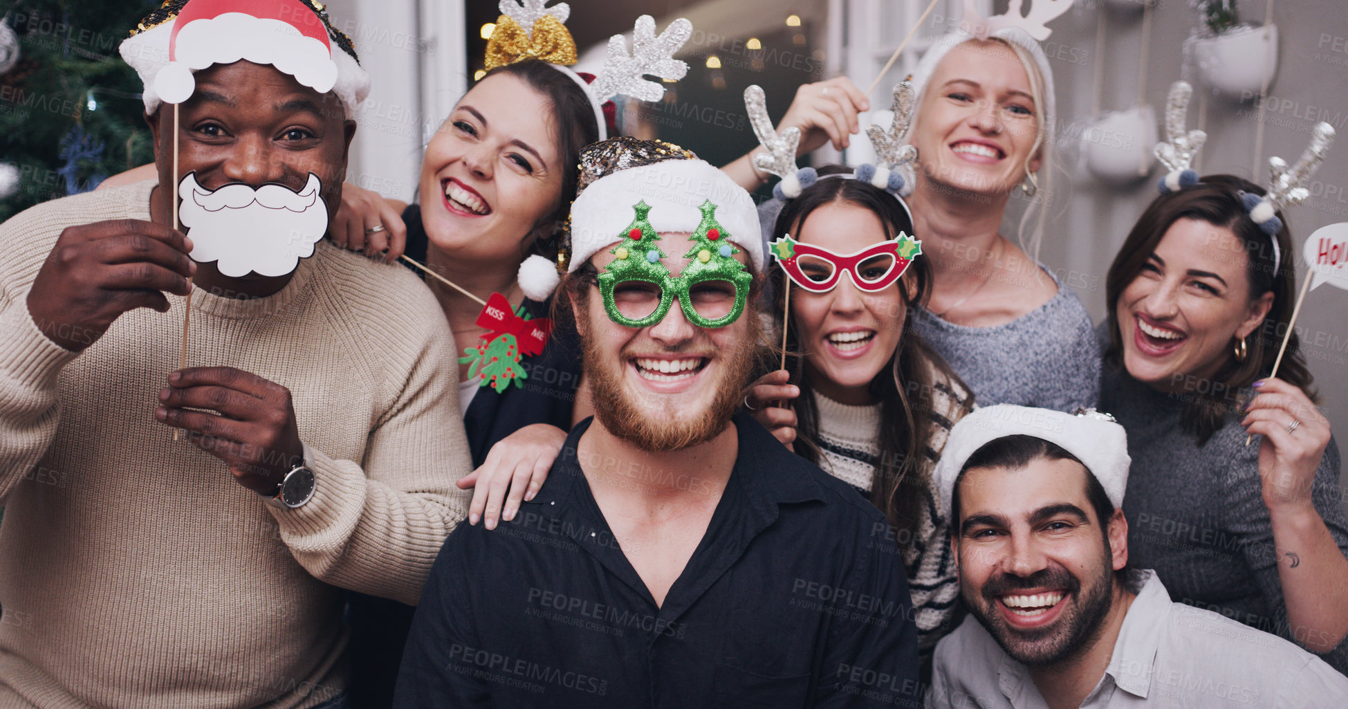 Buy stock photo Portrait of a group of young friends wearing funny hats and glasses at a Christmas party