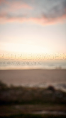 Buy stock photo Defocused shot of a beach at sunset