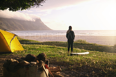 Buy stock photo Shot of an attractive young woman camping at her favourite surfing spot