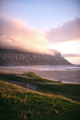 Buy stock photo Cropped shot of a mountainside beach at sunset