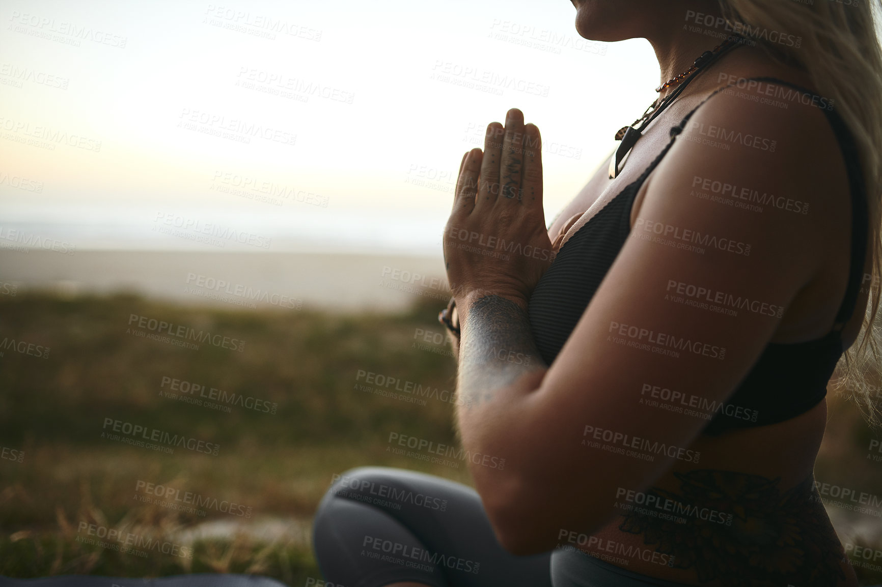 Buy stock photo Cropped shot of an unrecognizable woman sitting alone and meditating during a relaxing day outdoors