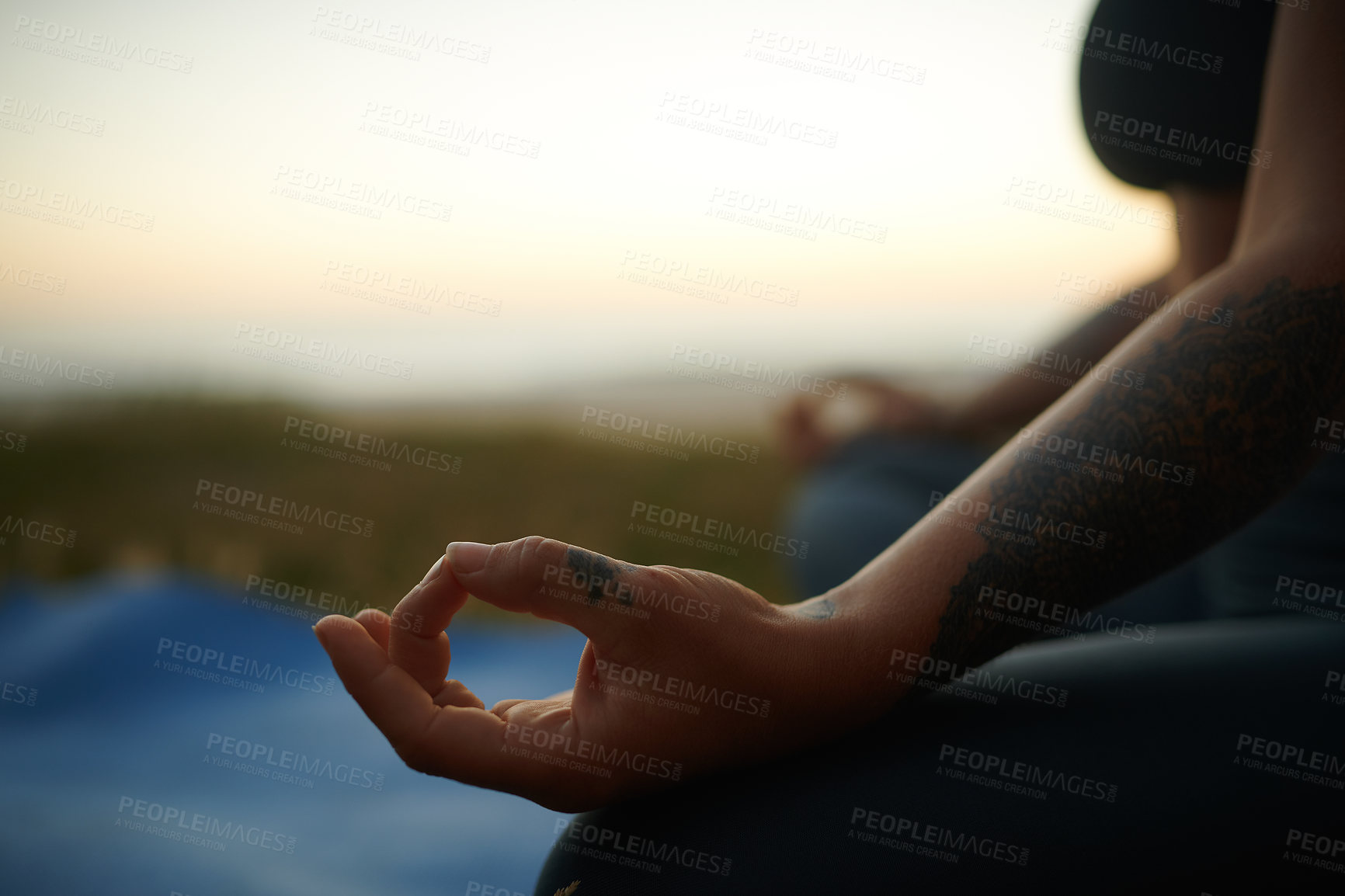 Buy stock photo Cropped shot of an unrecognizable woman sitting alone and meditating during a relaxing day outdoors