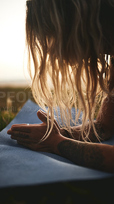 Buy stock photo Cropped shot of an unrecognizable woman holding a plank position during a yoga session outdoors
