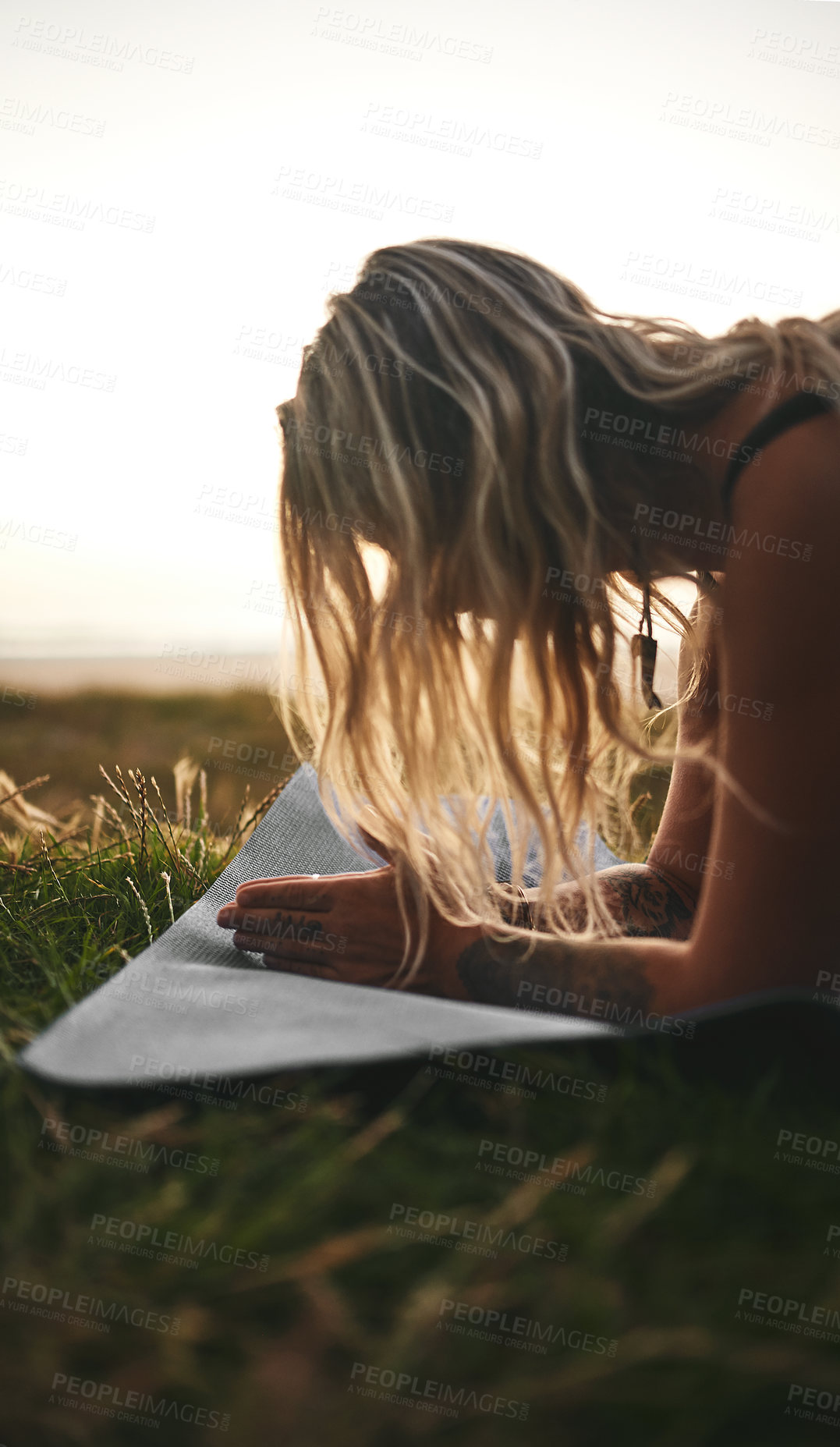 Buy stock photo Cropped shot of an unrecognizable woman holding a plank position during a yoga session outdoors
