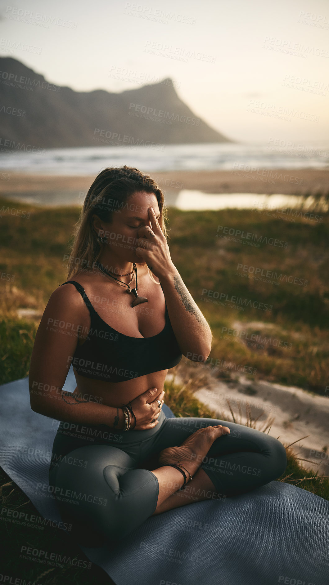 Buy stock photo Full length shot of an attractive young yogi sitting alone and putting pressure on the third eye pressure point