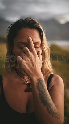 Buy stock photo Cropped shot of an attractive young yogi sitting alone and putting pressure on the third eye pressure point