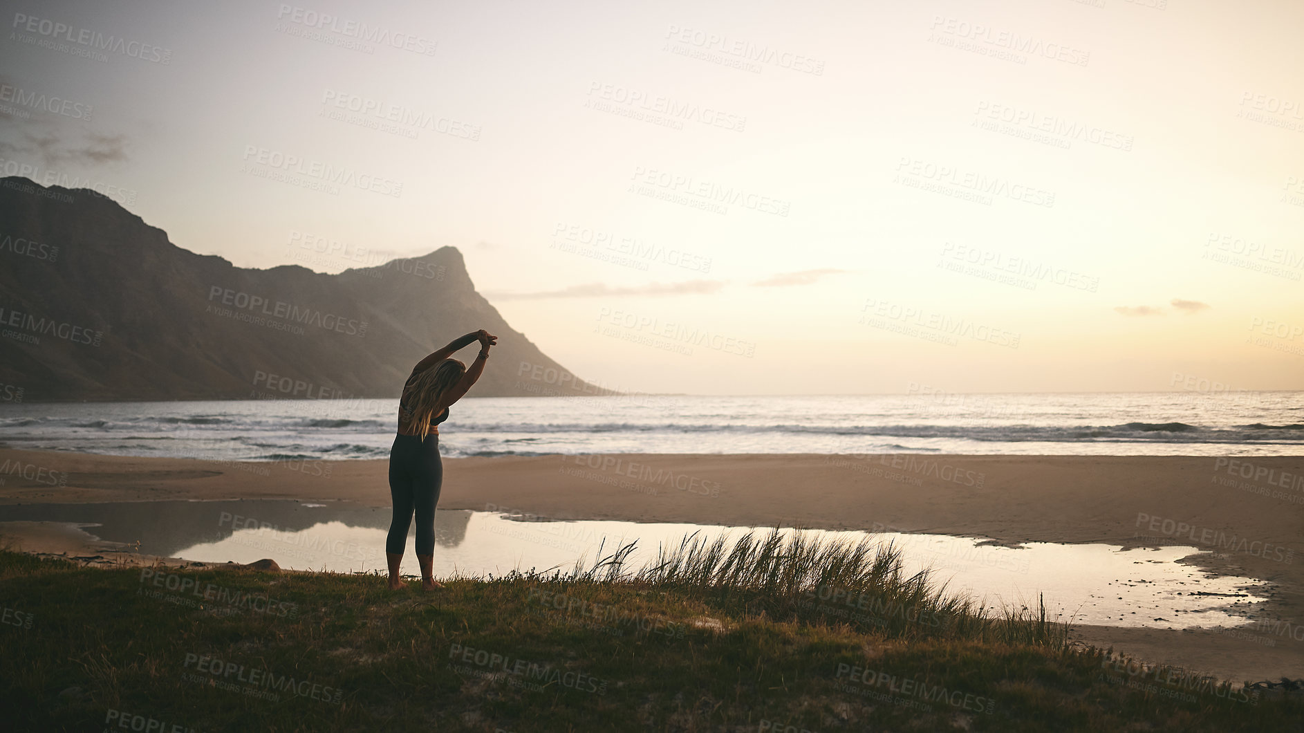 Buy stock photo Full length shot of an unrecognizable woman standing alone and stretching after a yoga session outdoors