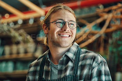 Buy stock photo Cropped shot of a handsome young businessman standing alone in his flower shop during the day