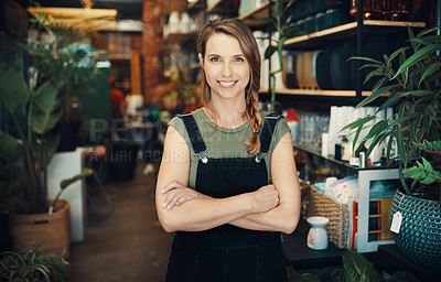 Buy stock photo Cropped portrait of an attractive young business owner standing in her floristry alone with her arms folded