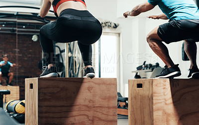 Buy stock photo Cropped shot of two unrecognizable sportspeople box jumping while working out in a gym