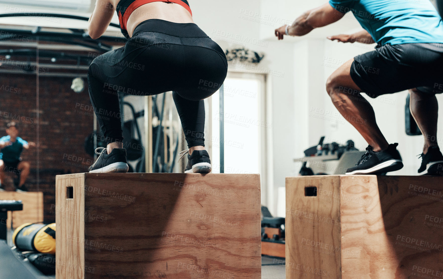 Buy stock photo Cropped shot of two unrecognizable sportspeople box jumping while working out in a gym