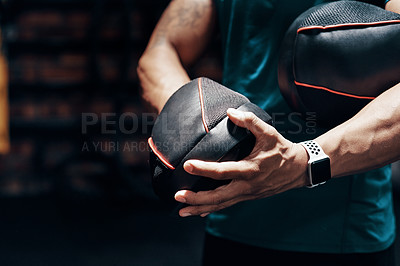 Buy stock photo Cropped shot of an an unrecognizable sportsman putting on protective gloves while working out in a gym