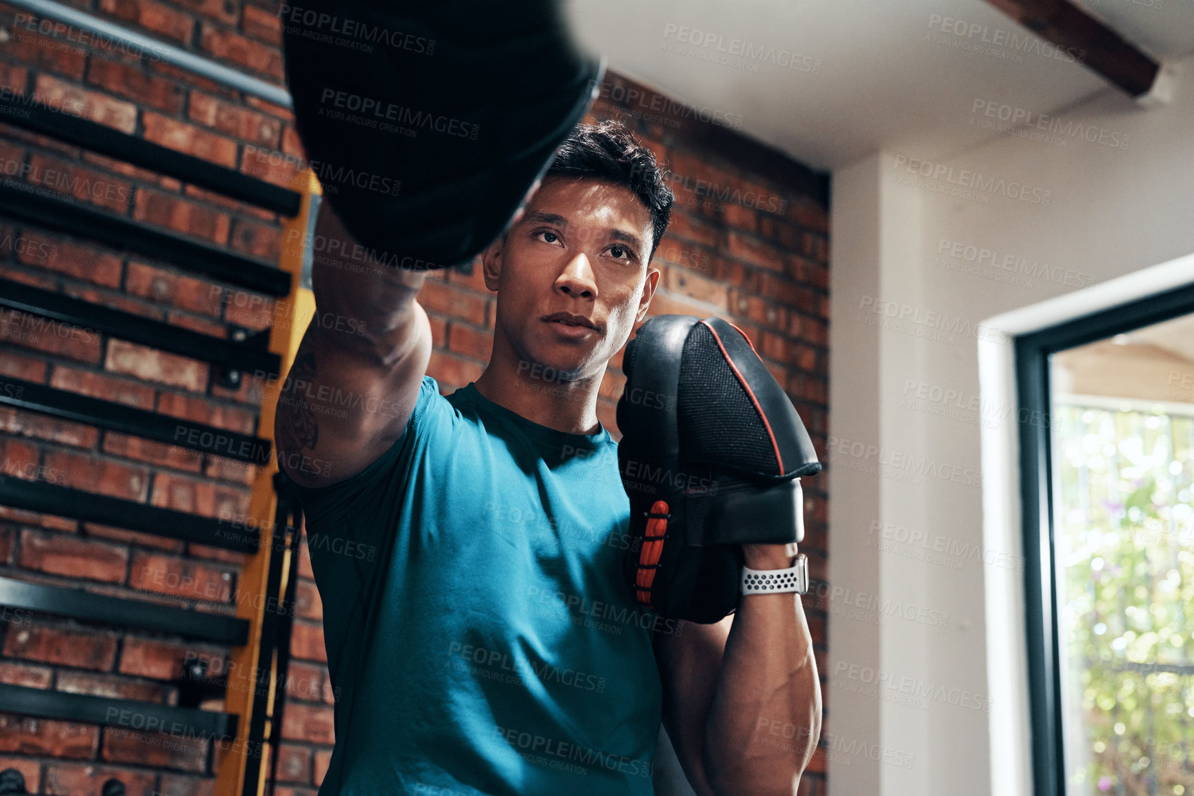 Buy stock photo Cropped shot of a handsome young male boxer working out in a gym