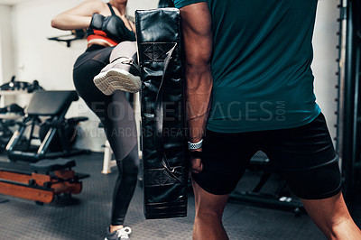 Buy stock photo Cropped shot of an unrecognizable female kick-boxer working out with her sparring partner in a gym