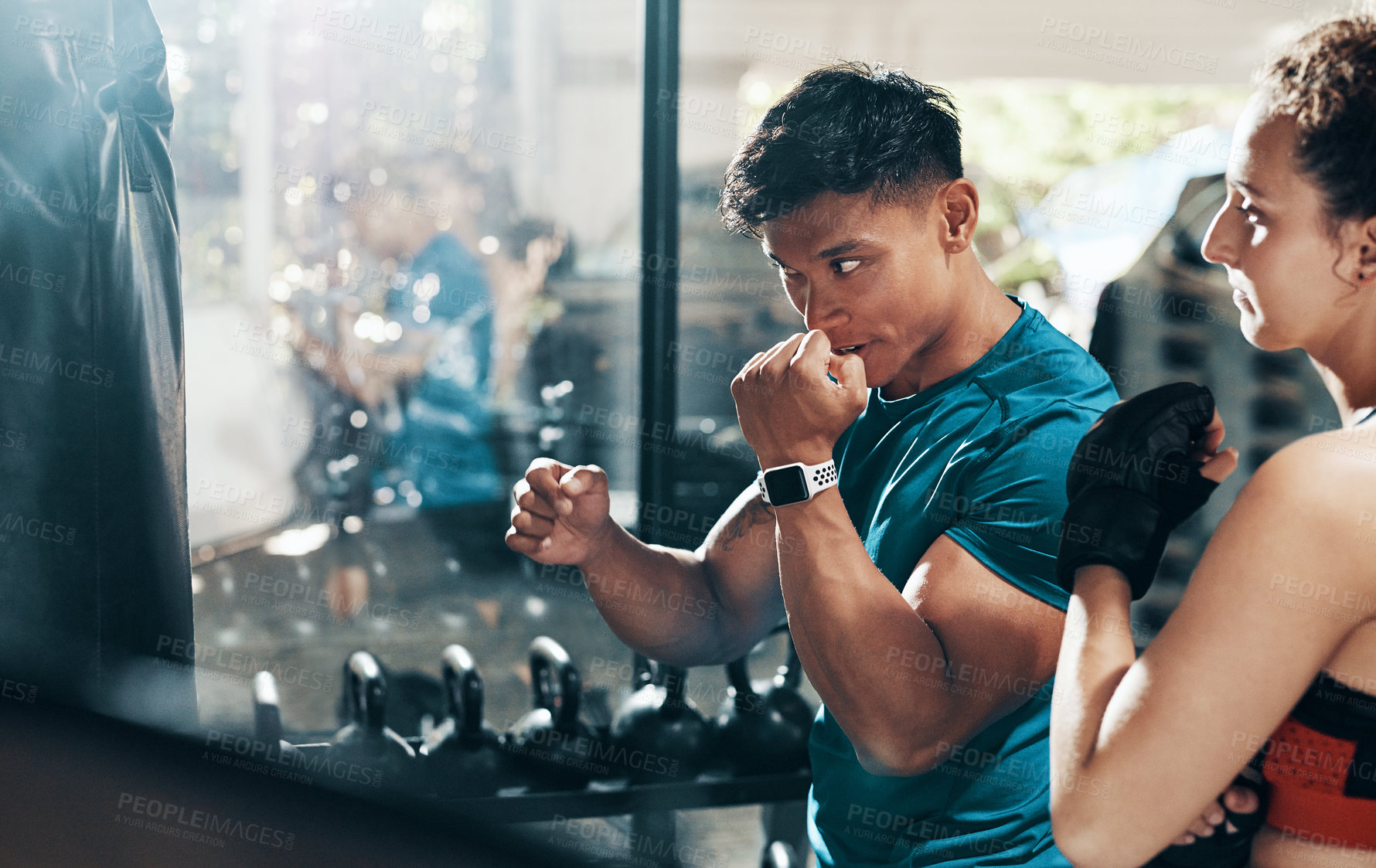 Buy stock photo Cropped shot of a handsome young male fitness instructor coaching a female boxer in a gym